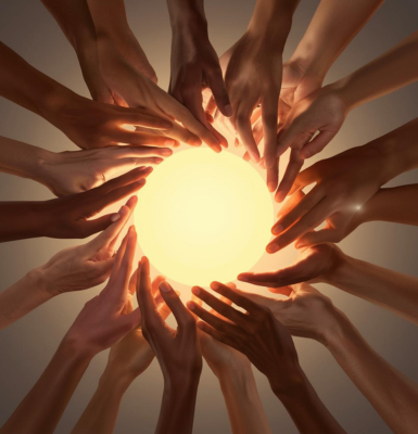 hands joined in a circle near a warm light 